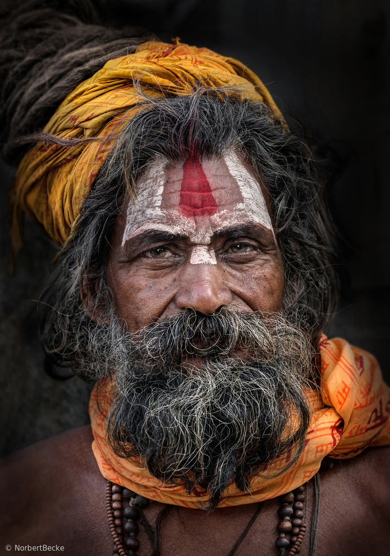 Sadhu with orange and yellow scarfs by Norbert Becke